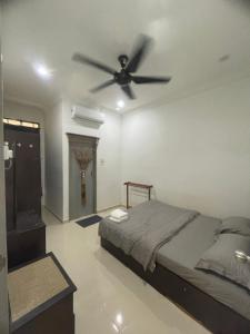 um quarto com uma cama e uma ventoinha de tecto em Homestay Cendana Gong Badak em Kampong Tanjong Gelam