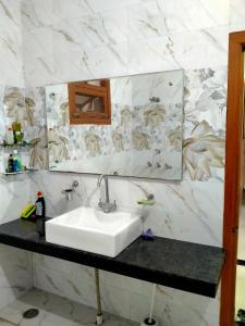 uma casa de banho com um lavatório e um espelho em Vishal's homestay em Rāja Sānsi