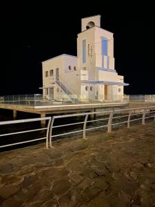un edificio bianco con torre dell'orologio di notte di Nador Bel Appart a Nador