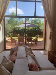 een woonkamer met een bank en een groot raam bij Villa Magnolia - Amelkis Golf in Marrakesh