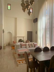 een woonkamer met een bank en een tafel bij Villa Magnolia - Amelkis Golf in Marrakesh