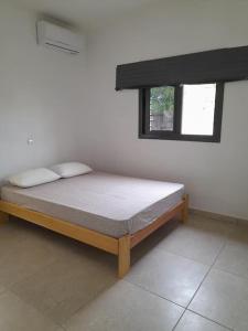 Bett in einem Zimmer mit Fenster in der Unterkunft Villa en résidence à Malibé Libreville in Libreville