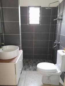 a bathroom with a white toilet and a sink at Villa en résidence à Malibé Libreville in Libreville