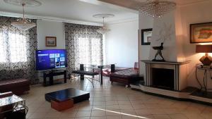 a living room with a fireplace and a tv at Silver Coast Village in Maceira
