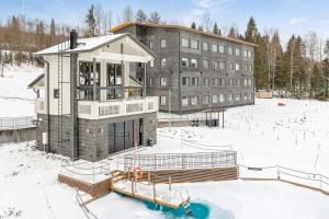 un edificio en la nieve frente a un edificio en Vuokatti Booking Suites, en Vuokatti