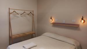 a bedroom with a bed and two lights on the wall at Holâ Hotel in La Falda +26 photos