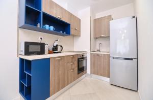 a kitchen with wooden cabinets and a refrigerator at Cozy 1-bed Apartment in Plovdiv
