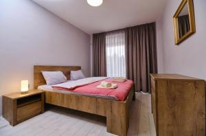 a bedroom with a bed with a red blanket at Cozy 1-bed Apartment in Plovdiv
