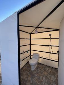 a bathroom with a toilet in a tent at Desert Stars Camp in Bidiyah