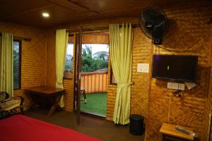 a room with a bedroom with a tv and a window at Riverine Homestay Kochin in Cochin