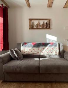 a couch with a blanket on it in a living room at Casa Felice in Caviola