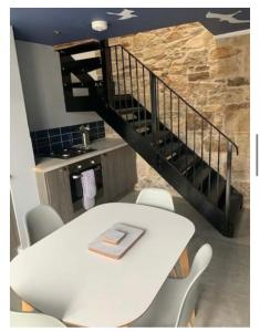 a white table with chairs and a staircase at Stable Door Cottage in Newquay