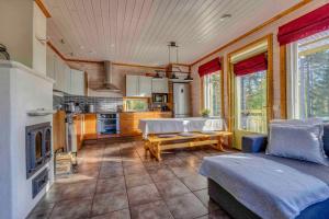 a living room with a couch and a kitchen at Lomahuvila Himoksen Pistaasi in Jämsä