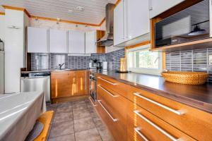eine Küche mit Holzschränken und einer Arbeitsplatte in der Unterkunft Lomahuvila Himoksen Pistaasi in Jämsä