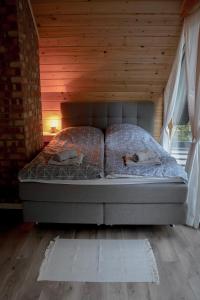 Ce lit se trouve dans un dortoir doté d'un plafond en bois. dans l'établissement Stacja Alpaka Mały Domek z Balią nad Zalewem Chańcza, à Raków