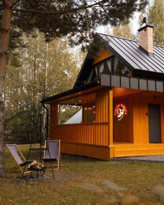 une cabine dans les bois avec un panneau. dans l'établissement Stacja Alpaka Mały Domek z Balią nad Zalewem Chańcza, à Raków