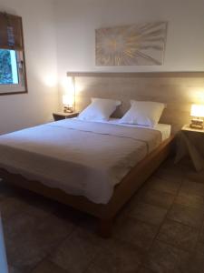 1 dormitorio con 1 cama grande con sábanas y almohadas blancas en Gîte Acellu, en Bonifacio