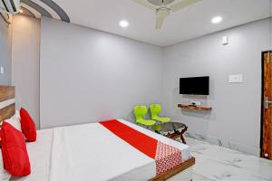 OYO Tara Maa Guest House في كولْكاتا: غرفة نوم بسرير وتلفزيون على جدار