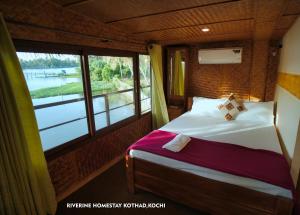 a bedroom with a bed and a large window at Riverine Homestay Kochin in Ernakulam