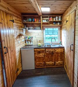 a kitchen with wooden cabinets and a sink in a log cabin at Nr3 - W POLU DOBREJ ENERGII 