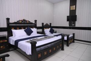 a bedroom with two beds and a flat screen tv at Hotel Serina Inn in Kalar Goth