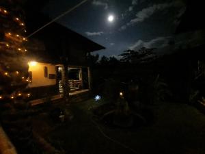 a house at night with the moon in the sky at Bambua Nature Cottages in Puerto Princesa City