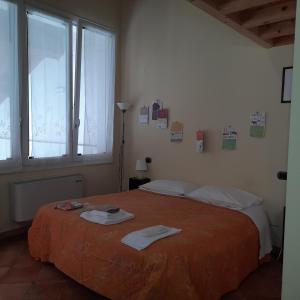 una camera da letto con un letto con lenzuola arancioni e una finestra di B&B Casa Pascolone a Pegognaga