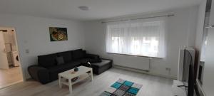 a living room with a couch and a tv at Blu Home/Ferienwohnung in Ostrach