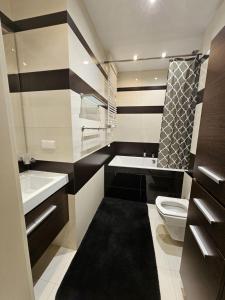un bagno bianco e nero con servizi igienici e lavandino di Royal Place 2 bedrooms Apartment Wilanów a Varsavia