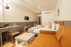 Habitación de hotel con cama y sofá en Krown Palace Resort, en Silvassa