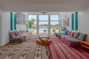 salon z kolorowymi meblami i basenem w obiekcie Stunning Villa for Rent in El Gouna HEATED PRIVATE POOL w mieście Hurghada