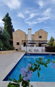una casa con piscina di fronte a un edificio di Villa Penelope a Douliana