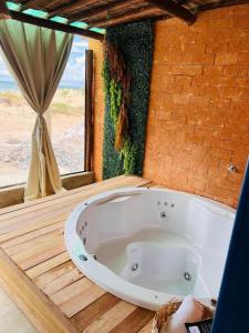 uma grande banheira branca num quarto com uma janela em Flats Villas Litoral Sul - Praia Pontal do Peba - Piaçabuçu - AL em Piaçabuçu