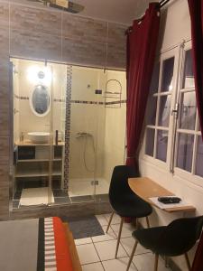 ein Bad mit einer Dusche sowie einem Tisch und Stühlen in der Unterkunft Happyhome in Saint-Pierre