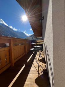 a chair on a balcony with a view of the mountains at Alpentime Apartments in Neustift im Stubaital