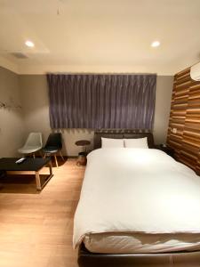 a bedroom with a large white bed and a window at Hotel JOYCE in Saijō-chō