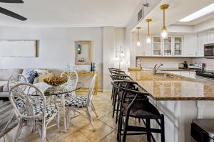 a kitchen and living room with a table and chairs at Arena De Madeira 502- Premier in St Pete Beach