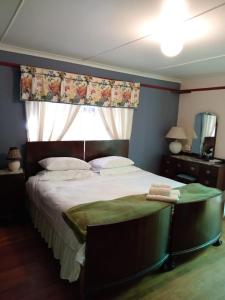 a bedroom with a large bed with a window at Zoete Inval in Hermanus