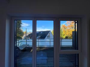 une fenêtre ouverte avec vue sur une maison dans l'établissement LIBORIA I Stylisches Haus I Sauna I Wellness, à Starnberg