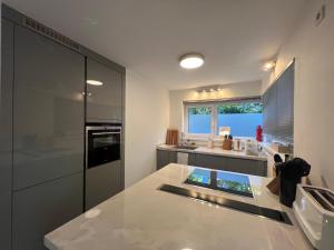 a large white kitchen with a large counter top at LIBORIA I Stylisches Haus I Sauna I Wellness in Starnberg
