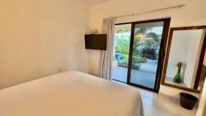 - une chambre avec un lit et une grande fenêtre dans l'établissement Casa Puerto Viejo, à Puerto Escondido