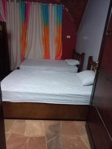 Łóżko w pokoju z zasłoną tęczową w obiekcie Hoolli Villa w mieście Aswan