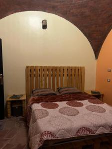 sypialnia z dużym łóżkiem z ceglaną ścianą w obiekcie Hoolli Villa w mieście Aswan