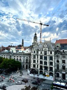 un grand bâtiment avec une grue devant lui dans l'établissement Hotel Universal, à Porto