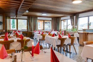 um restaurante com mesas e cadeiras com guardanapos vermelhos em Gasthof zum Sessellift em Mitterbach