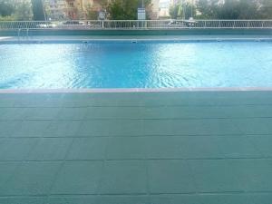 a swimming pool with blue water in a building at Beach Nice Flat in Puebla de Farnals