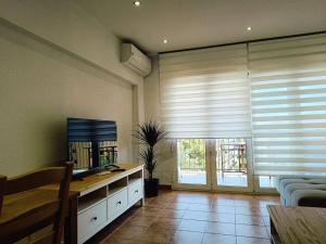 a living room with a large window with blinds at Beach Nice Flat in Puebla de Farnals