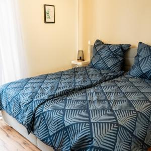 Schlafzimmer mit einem Bett mit einer blauen und weißen Bettdecke in der Unterkunft M Apartment Charme - gemütlich geräumig heimisch in Landau in der Pfalz