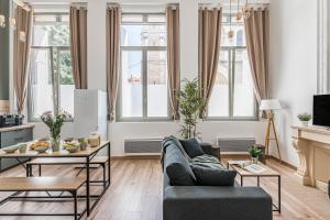 a living room with a couch and a table at Charmant & spacieux appartement en cœur de ville in Saint-Étienne