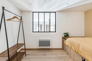 - une chambre avec un lit et une fenêtre dans l'établissement Charmant & spacieux appartement en cœur de ville, à Saint-Étienne